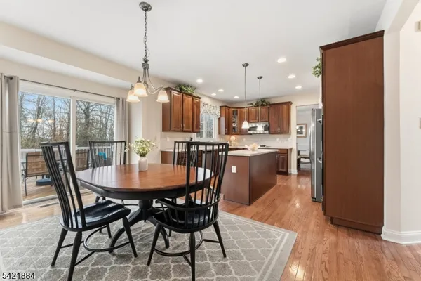 a view of a dining room and livingroom with furniture wooden floor a chandelier