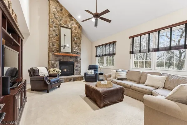 a living room with furniture a fireplace and a large window