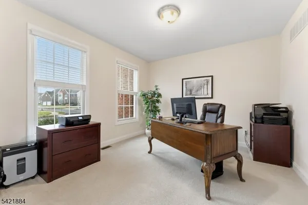 a view of a workspace with furniture and a window