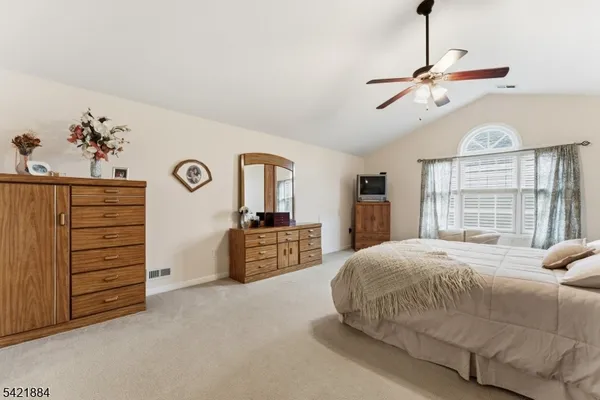 a spacious bedroom with a bed and a dresser