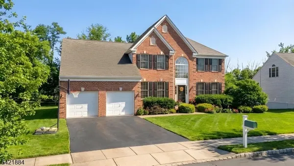 a front view of a house with a yard and trees