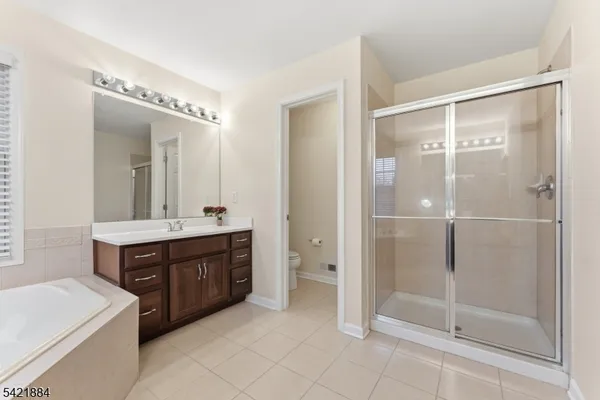a spacious bathroom with a shower sink and mirror