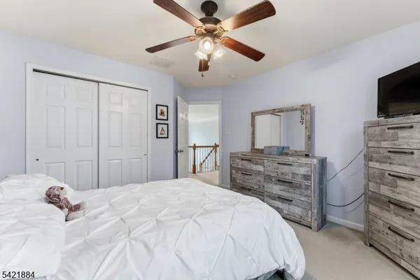 a bedroom with a bed and a flat tv screen on dresser