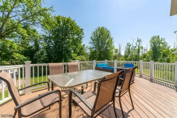 a balcony with wooden floor table and chairs