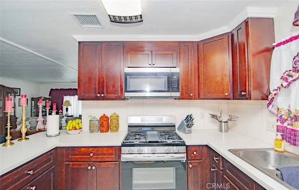 a kitchen with stainless steel appliances granite countertop a sink a stove and a microwave