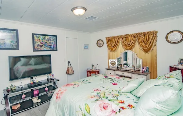 a bedroom with a large bed and a wooden floor