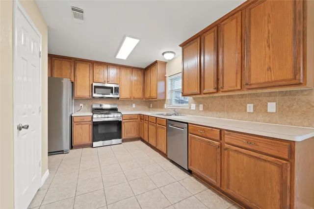a kitchen with stainless steel appliances granite countertop a refrigerator sink and cabinets