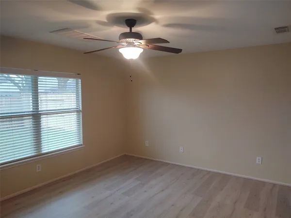 wooden floor in an empty room with a window