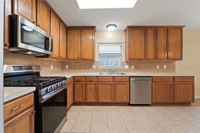 a kitchen with stainless steel appliances granite countertop a stove top oven microwave and cabinets