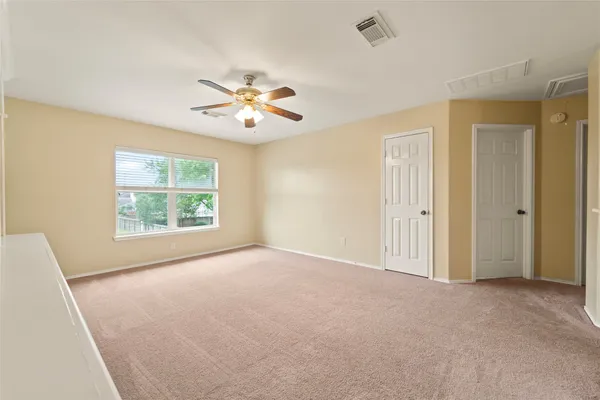 an empty room with window and ceiling fan