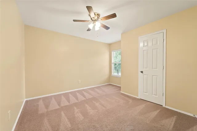 an empty room with closet and ceiling fan