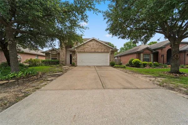 a front view of a house with a yard and trees