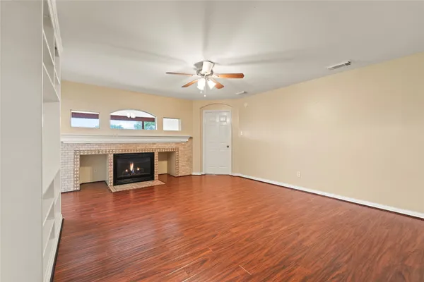 a view of an empty room with a fireplace and a chandelier