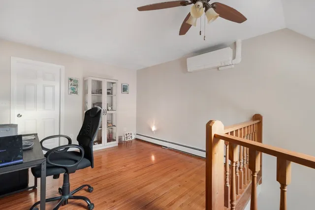 a view of a workspace with furniture and wooden floor