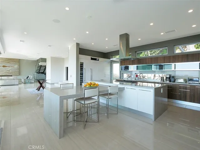 a kitchen with stainless steel appliances kitchen island granite countertop a table and chairs