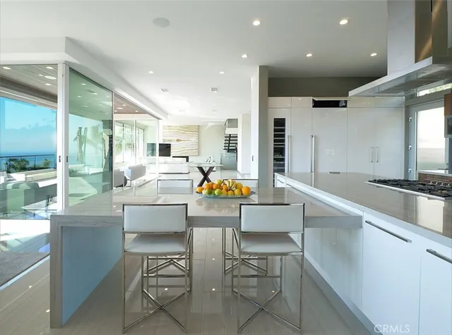 a kitchen with stainless steel appliances granite countertop a sink and chairs