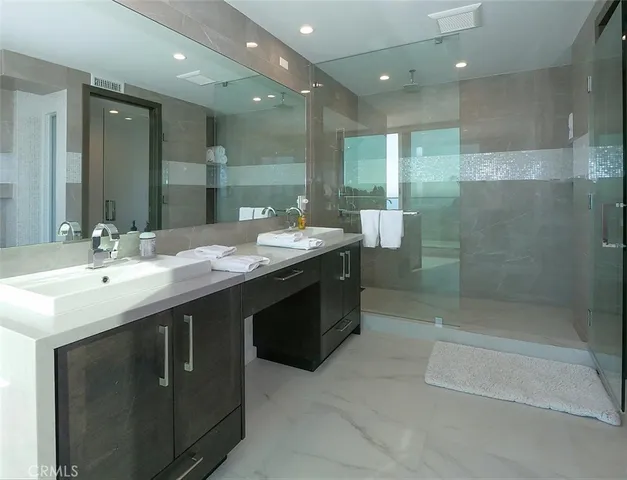 a bathroom with a sink shower and a mirror