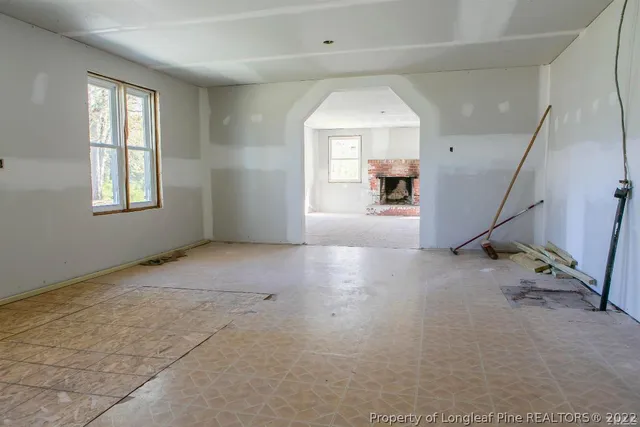a view of an empty room with a fireplace and a window