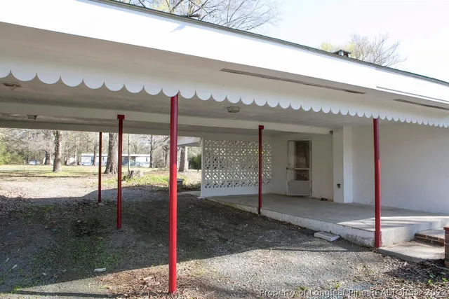 a view of a house with a yard covered with trees