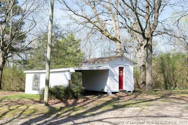 a view of a grassy field with trees in the background
