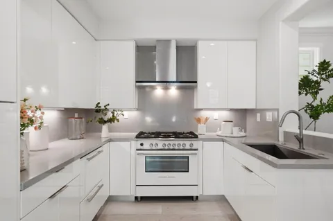 a kitchen with white cabinets and white appliances