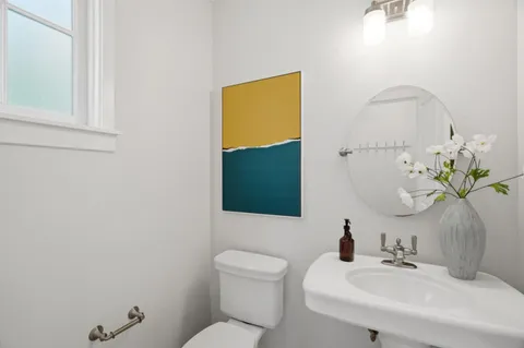 a bathroom with a toilet sink and mirror