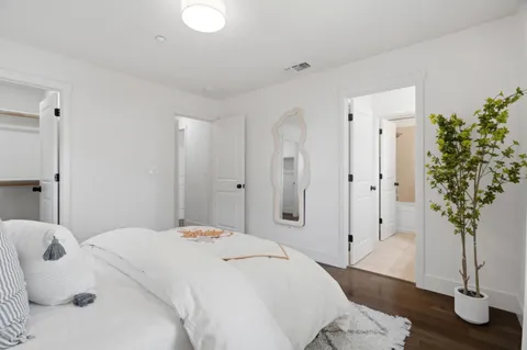 a bedroom with a bed and a potted plant