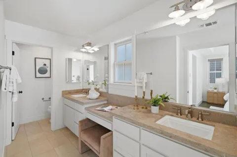 a bathroom with a granite countertop sink a large mirror and a shower