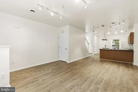 a view of kitchen and hall with wooden floor