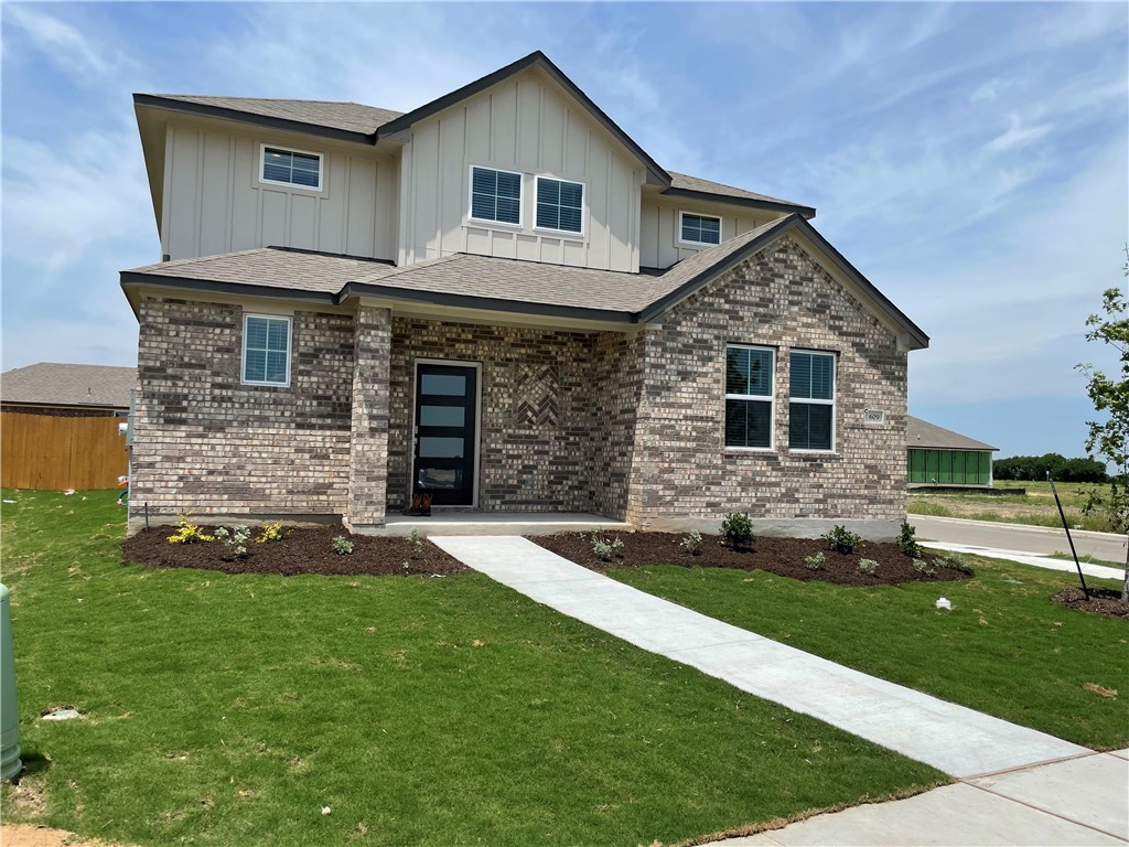 609 Paddock Lane Georgetown, TX 78626 - Photo 4 of 40 A concrete walkway leads to the covered front entryway of this two-story brick residence.