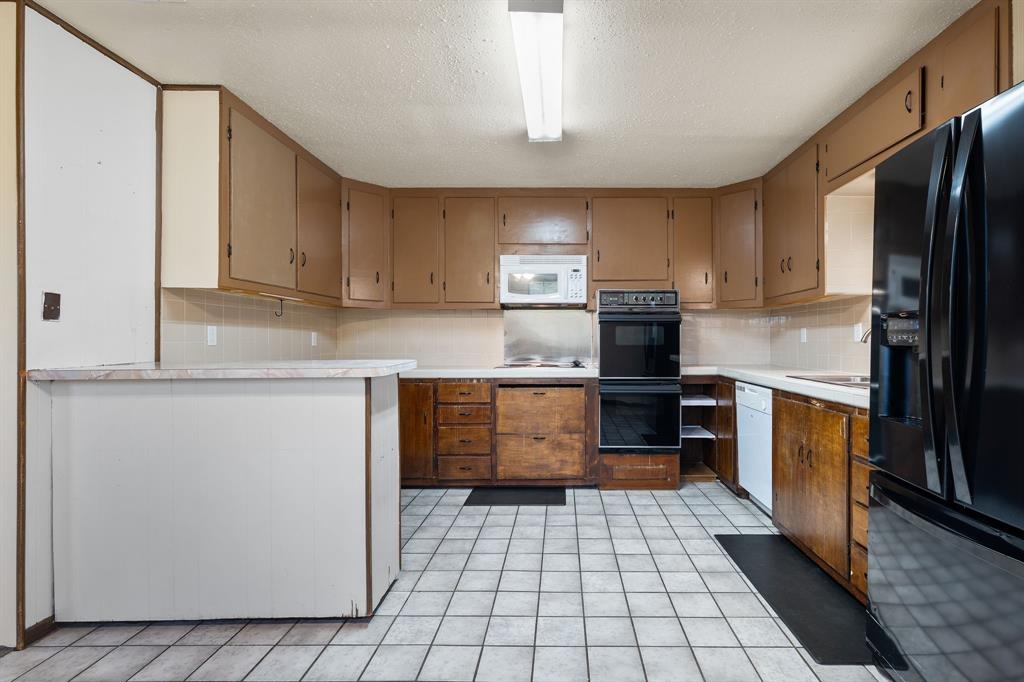 373 Ingred Street Waco, TX 76705 - Photo 9 of 39 a kitchen with a refrigerator sink and cabinets