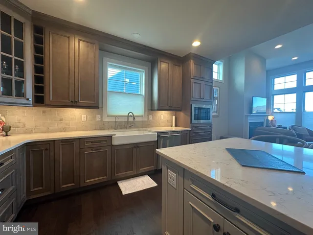 a kitchen with granite countertop kitchen island stainless steel appliances a sink stove and refrigerator