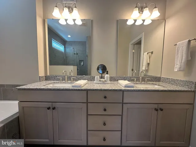 a bathroom with a granite countertop sink a toilet and a mirror