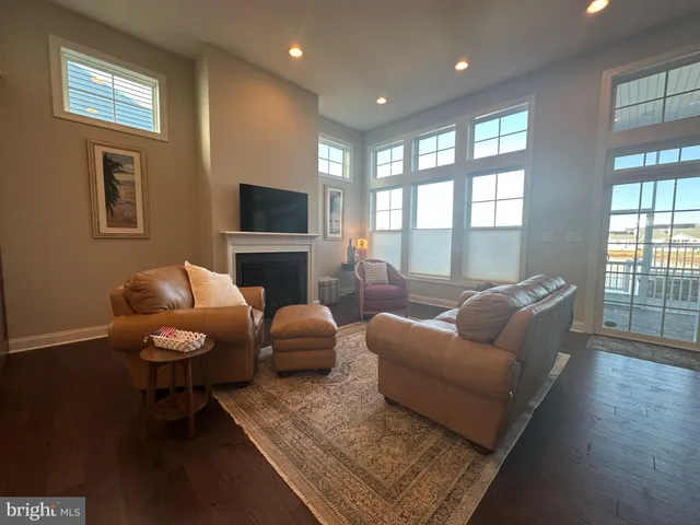 a living room with furniture a flat screen tv and a large window