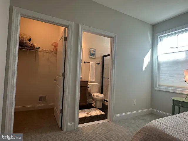 a view of a bedroom with a bed and a window
