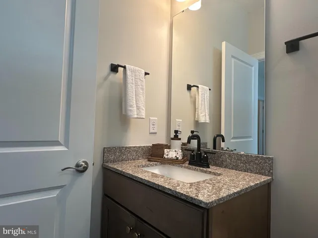 a bathroom with a granite countertop sink and a mirror