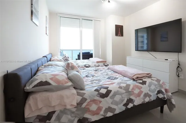 a bedroom with a bed and a flat screen tv