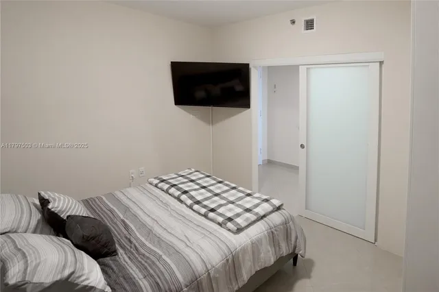 a bedroom with a bed and a flat screen tv
