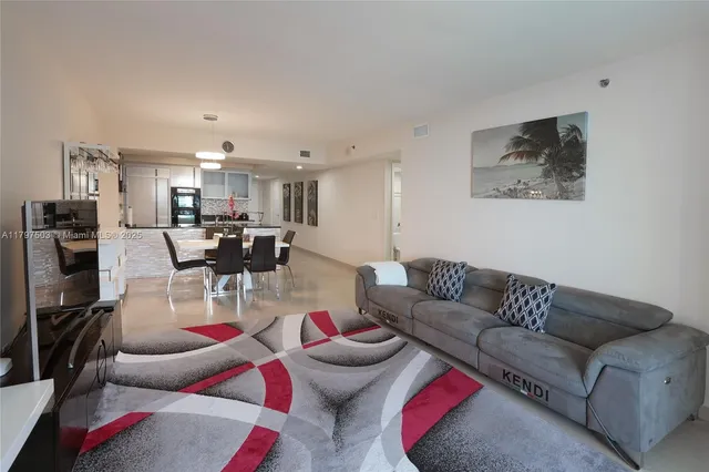 a living room with furniture and kitchen view