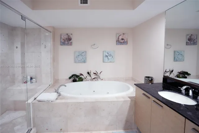 a bathroom with a granite countertop sink and a bathtub