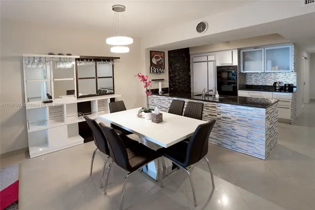 a dining area with a table chairs and a kitchen view