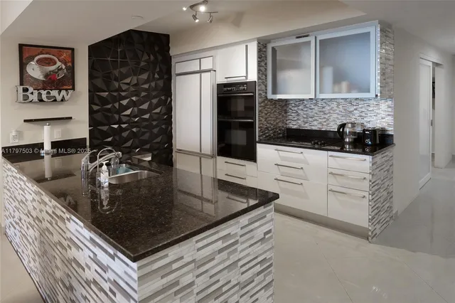 a kitchen with stainless steel appliances granite countertop a sink and a refrigerator