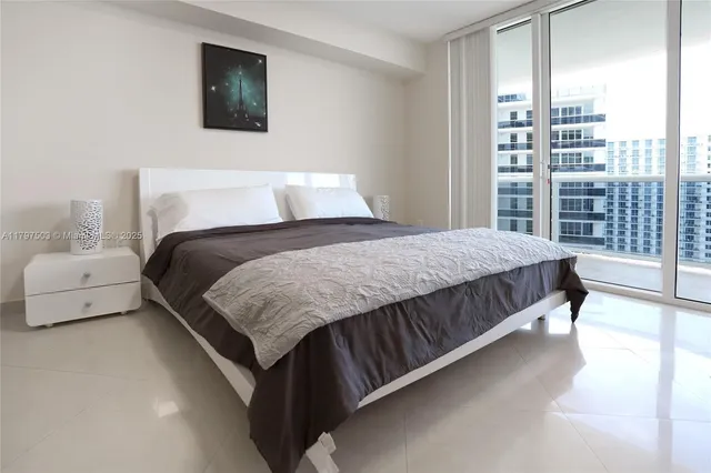 a bedroom with a large bed and a night stand