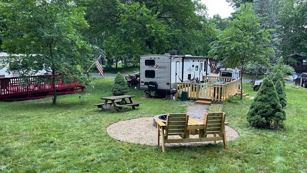 a view of a chair and table in backyard of the house