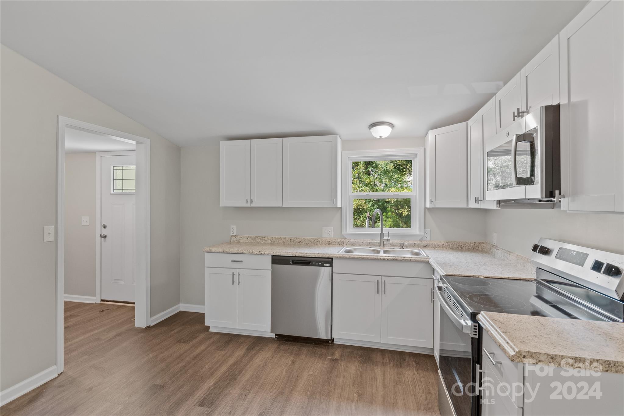 22 Potter Street Mill Spring, NC 28756 - Photo 8 of 15 a kitchen with stainless steel appliances granite countertop a sink cabinets and wooden floor