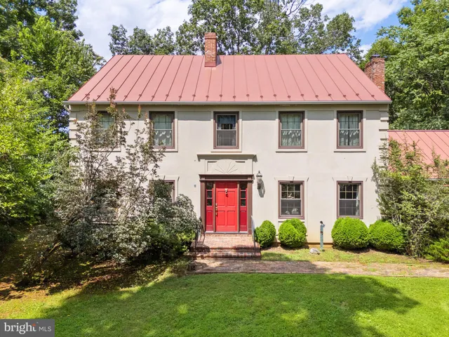 a view of a yard in front of a house with large windows
