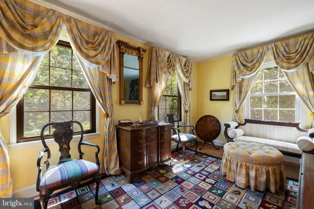 a living room with furniture a fireplace and large windows