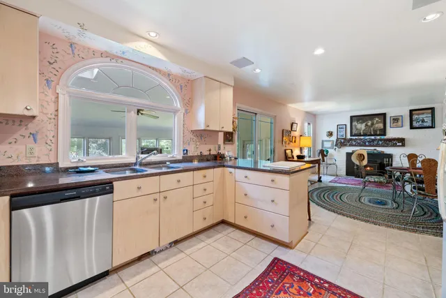 a living room with furniture a fireplace and a floor to ceiling window