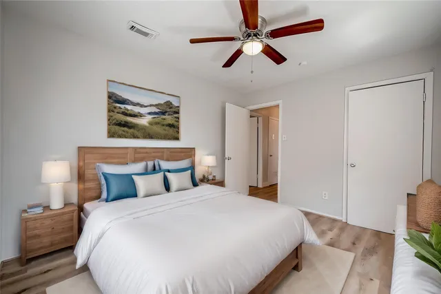 a bedroom with a large bed and a chandelier