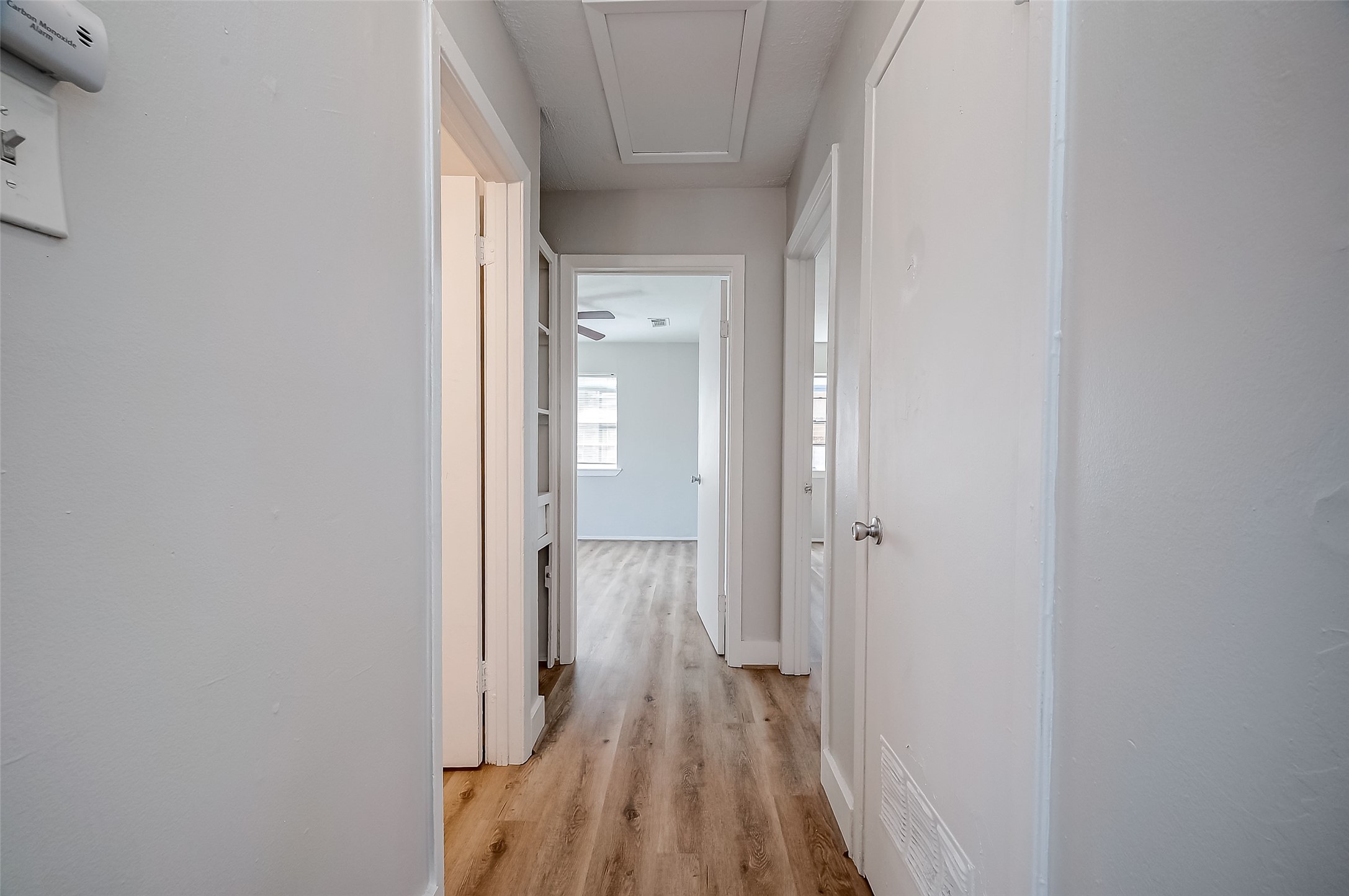 8814 Manus Street, Unit 5 Houston, TX 77093 - Photo 24 of 27 Bright, inviting hallway with light-colored walls and wood flooring leading to multiple rooms. Perfect for easy home navigation.